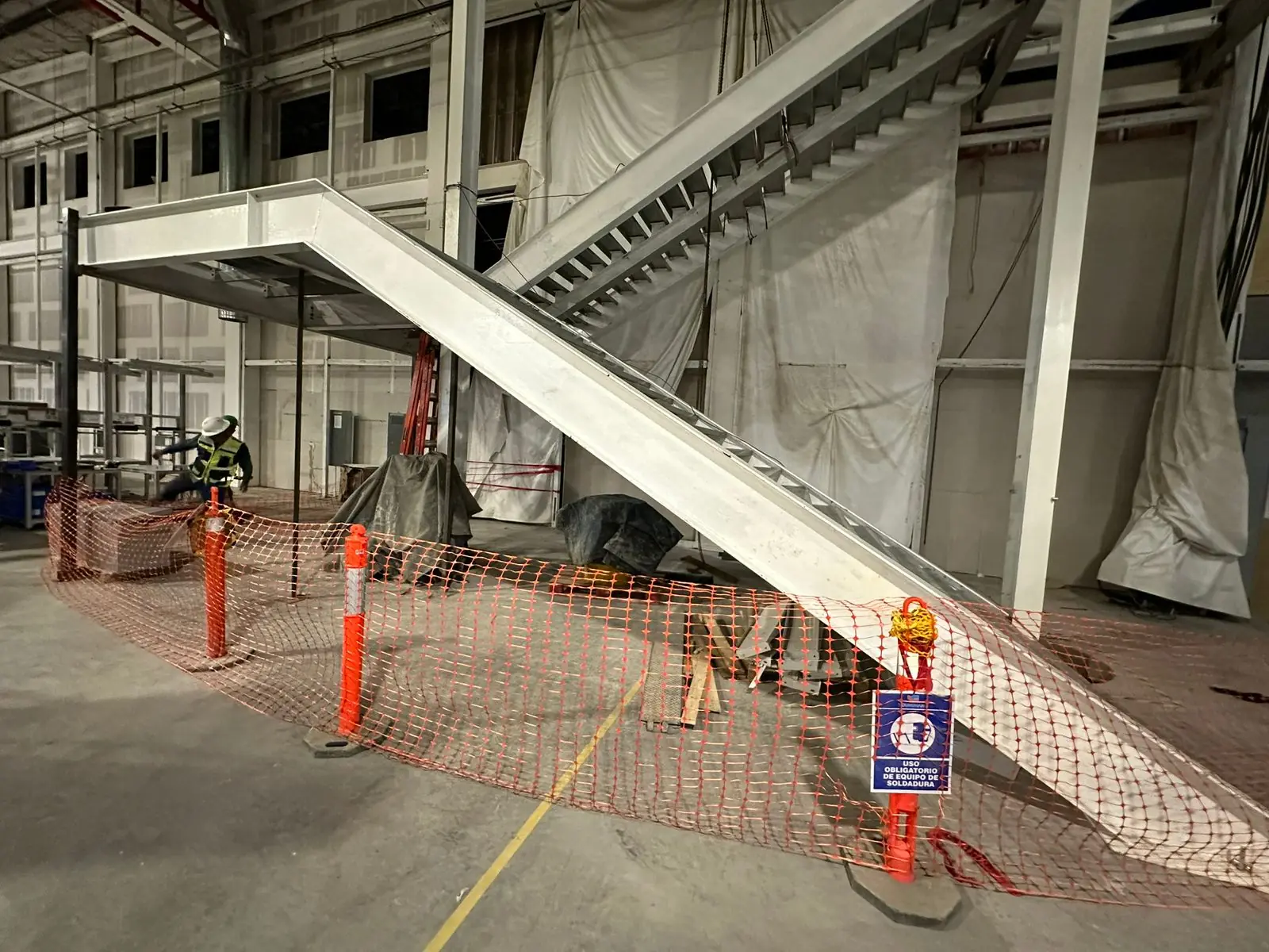 Estructura metálica de escalera en montaje con área delimitada